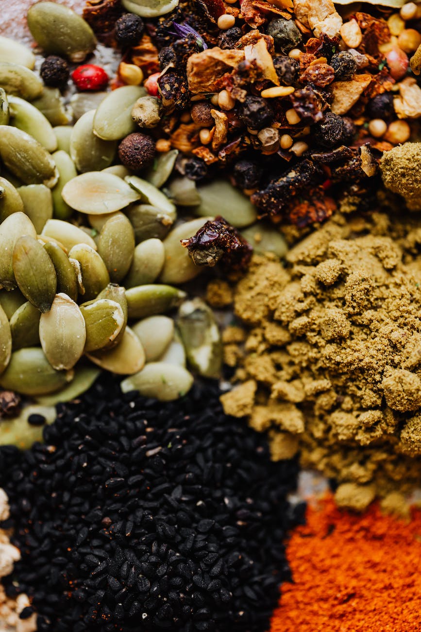 spices and herbs beside pumpkin seeds in close up view