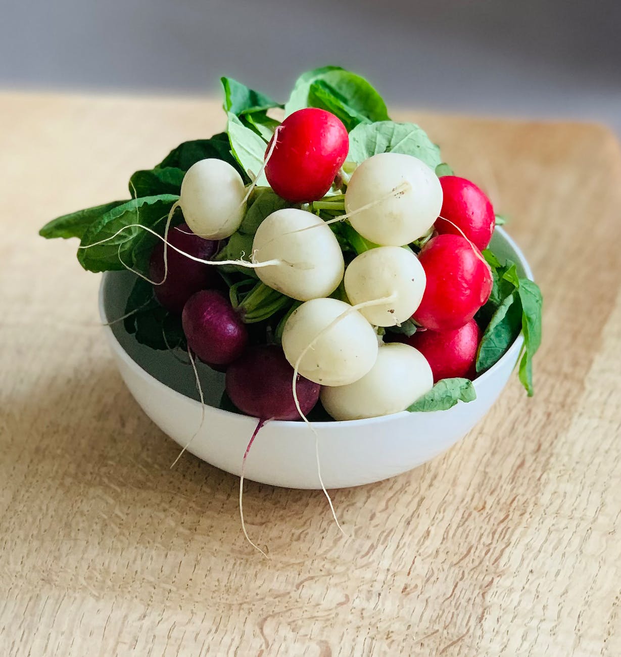 a bowl of fresh round red and white radish