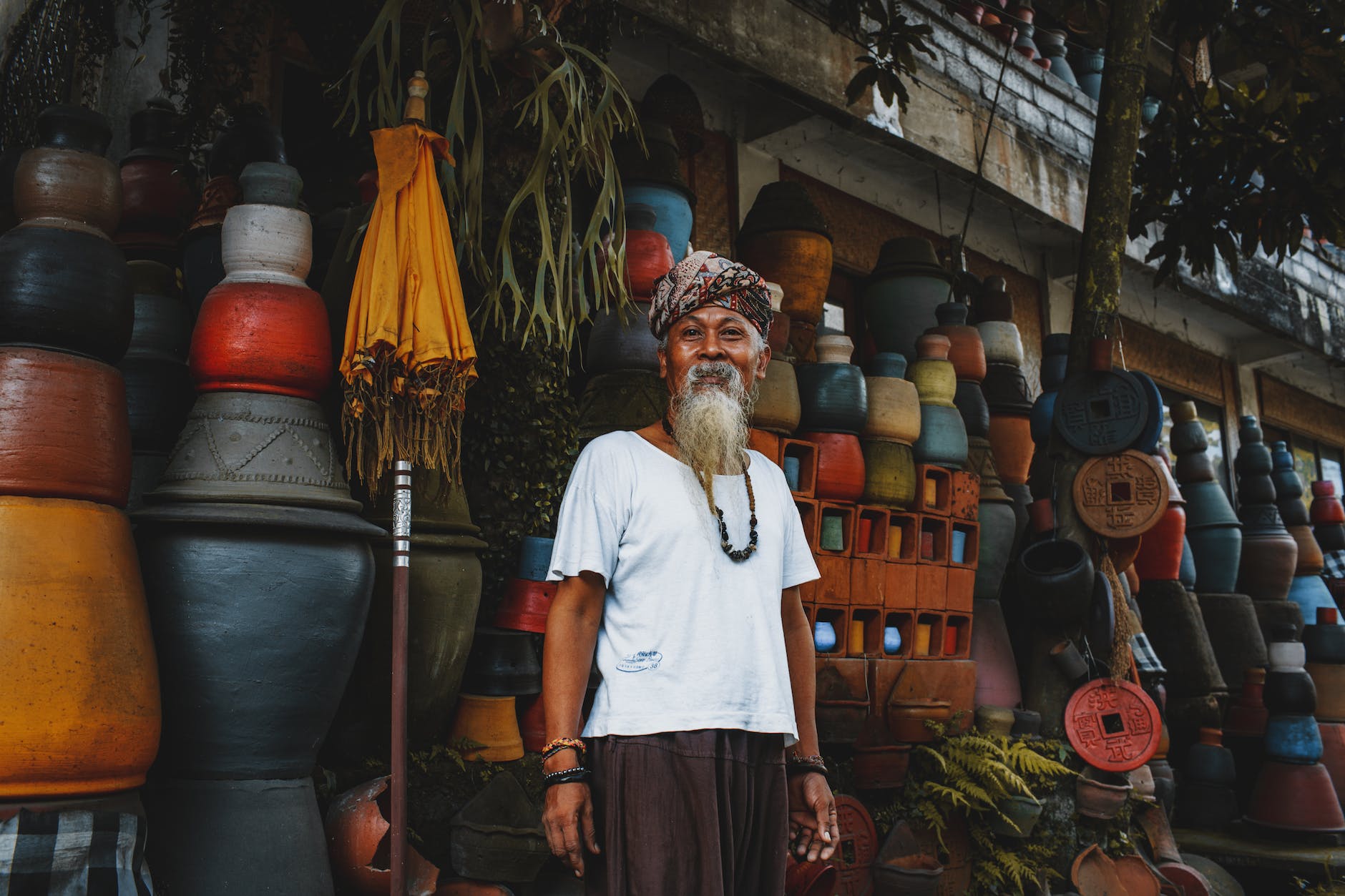 ethnic old man standing on street market