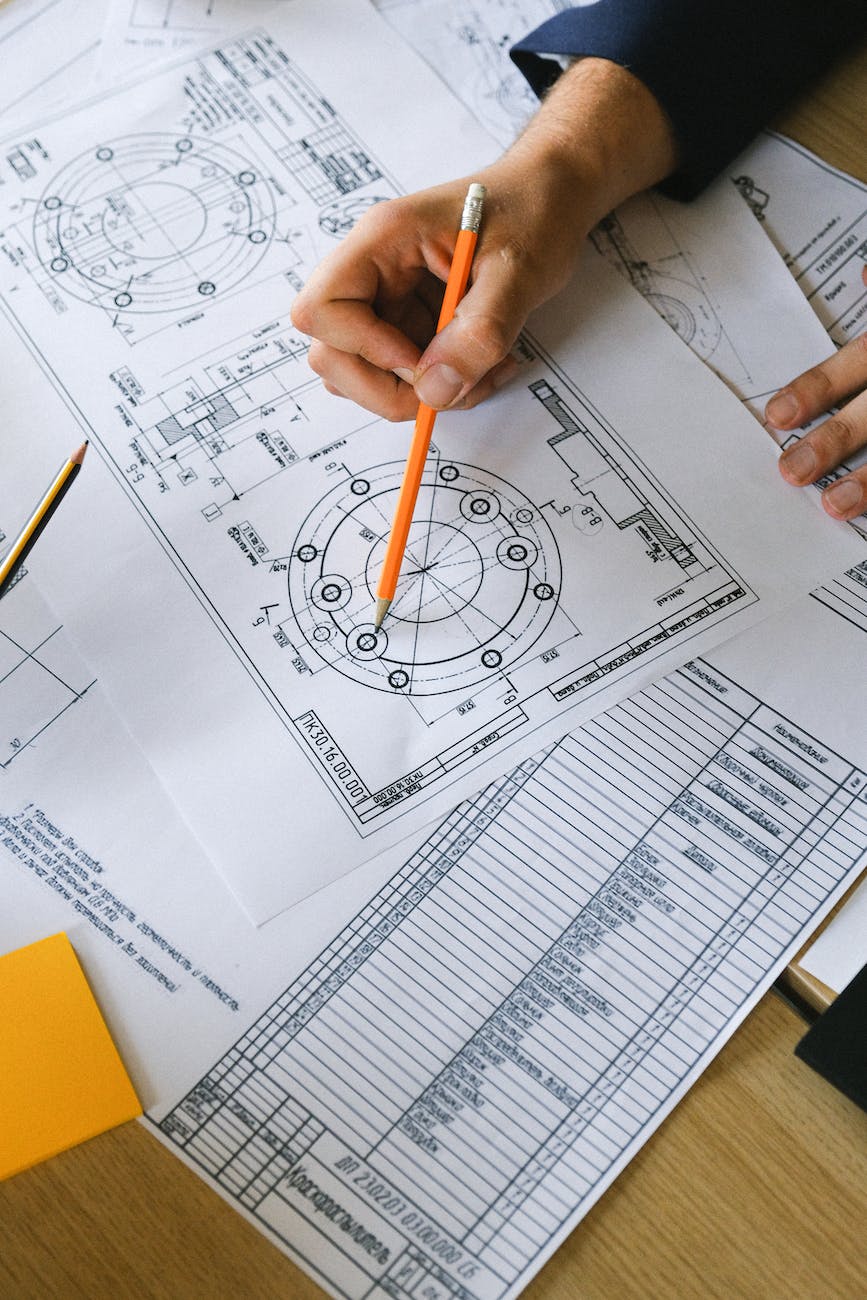 man working with scheme on paper at table